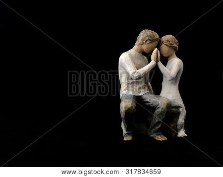 The Figure Of A Couple In Love. The Statuette He And She - Love. A Man And A Woman Are Sitting, Hugg