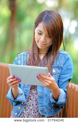 jovem mulher asiática com computador tablet ao ar livre