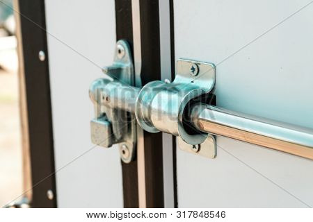 Photograph Of A Metal Lock On A White Door
