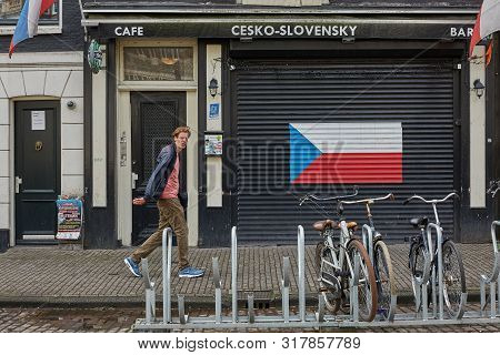 Man Walking By Czech Slovak Bar In Amsterdam Netherlands