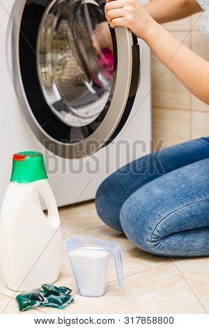 Washing Powder Detergent And Measuring Cup Next To Machine In Bathroom. Household Duties, Clothes La