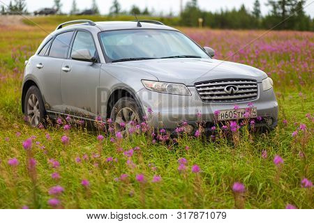 Novyy Urengoy, Russia - August 3, 2019: Grey Crossover Infiniti Fx35 In The Field Of Purple Flowers.