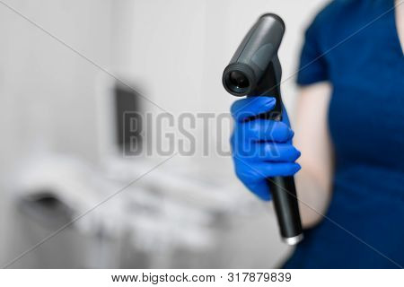 Doctor Hand In Blue Rubber Glove Hold Professional Ophthalmologist Tool Ophthalmoscope.
