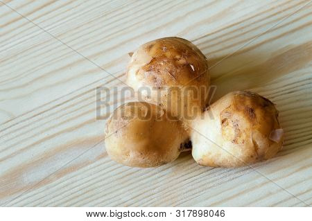 Conjoined Siamese Potato Wooden Table Background With Copy Space. Potential Use As Wonky Funny Ugly 