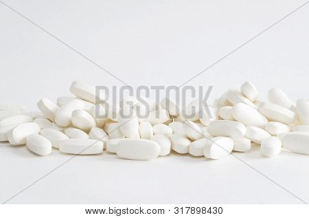 Group Of White Magnesium Pills On White Backgrond