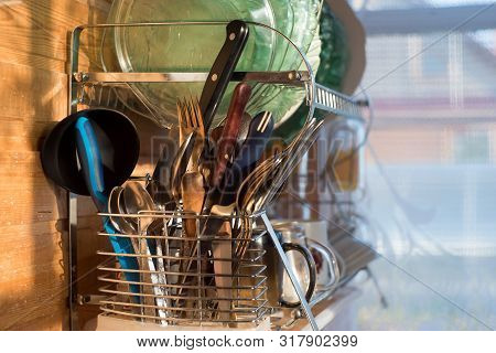 Home Kitchen. Clean Washed Dish Ware Drying On A Drainer Mounted In Kitchen. Clean Dishes Is Spoon, 