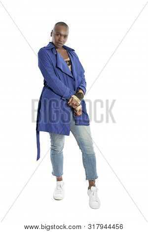 Black African American Fashion Model With Bald Hairstyle Confidently Posing With A Vibrant Blue Colo