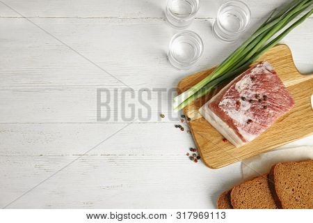 Board With Pork Fatback, Onion, Bread And Shots Of Vodka On White Wooden Background, Flat Lay. Space