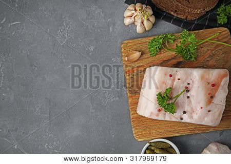 Board With Pork Fatback, Garlic, Parsley, Bread And Bowl Of Pickles On Grey Stone Background, Flat L