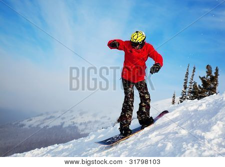 Snowboardista skoky vzduchem s tmavě modrou oblohou v pozadí