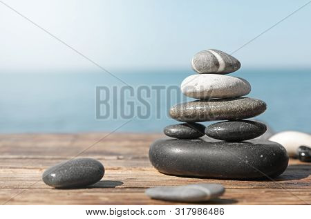 Stack Of Stones On Wooden Pier Near Sea Seascape, Space For Text. Zen Concept