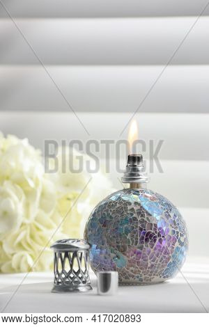 Burning Catalytic Purifying Lamp And Flowers On Window Sill. Interior Element