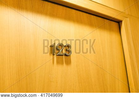 The Door Of The Room In The Hotel With Number 123. Closed Wooden Door In The Hotel.