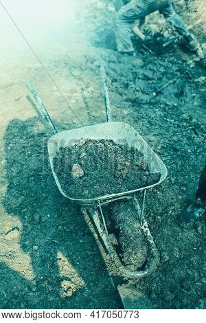 Wheelbarrow Filled With Dirt.worker In Background.high Quality Photo.