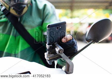 The Hand Of The Food Delivery Attendant Is Pressing The Smartphone On The Motorbike To Accept The On