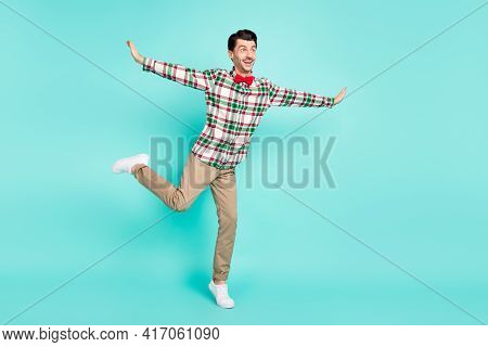 Photo Of Man Dance Hands Wings Plane Pose Stand One Leg Wear Plaid Shirt Bow Pants Isolated Blue Col