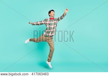 Photo Of Crazy Guy Jump Hand Hold Empty Space Look Up Wear Plaid Shirt Tie Pants Shoes Isolated Blue