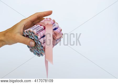 Female Hand Holding Ukrainian Money Wrapped With A Ribbon.