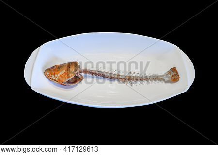 Close Up Of Fishbone After Dinner In White Plate And Isolated On Black Background.