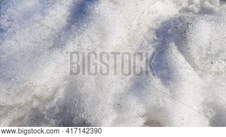 Close-up Of Dirty Snow With Frozen Ice In Early Spring. Sunlight And Shadows On Snow Texture, The Co