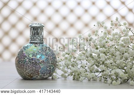 Beautiful Catalytic Purifying Lamp And Flowers On Table. Interior Element