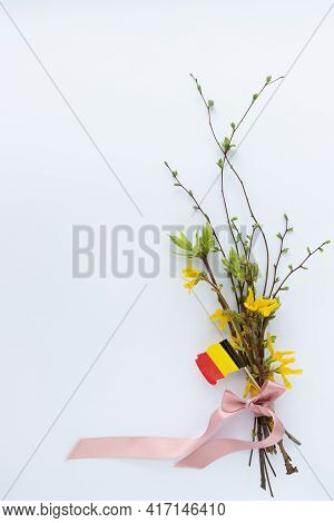 Spring Bouquet Of Twigs With Leaves And Flowers With A Flag Of Belgium.