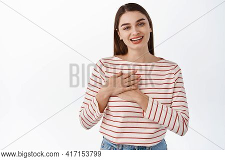 Thank You. Smiling Heartfelt Woman, Feeling Touched Or Flattered, Holding Hands On Chest And Looking