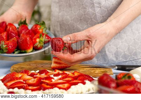Woman Baker Stacks Strawberries On Meringue Strawberry Cake Base. Homemade Strawberries Cake Made Fr