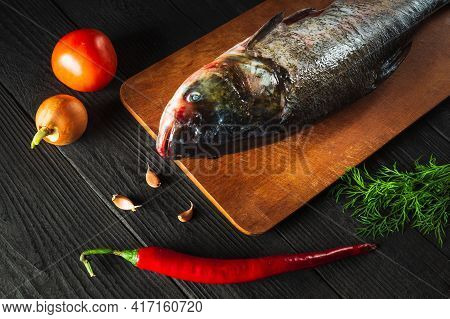 Hypophthalmichthys Or Bighead Carp On Cutting Board With Vegetables Before Cooking. Raw Peeled Fish 