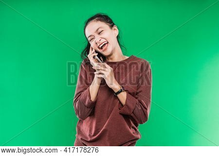 Young Woman Is Talking On The Phone Laughing Happily With Someone