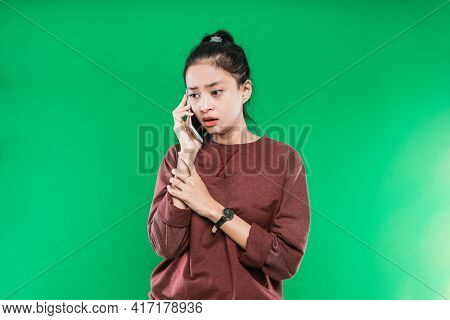 Portrait Young Asian Woman Talking On The Phone With A Sad, Shocked Expression