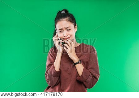 Portrait Young Asian Woman Talking On The Phone With A Crying, Shocked Expression While Holding His 
