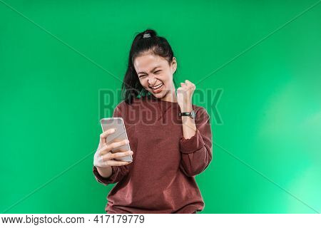 Beautiful Young Woman Looking At Something On The Cellphone With A Happy Expression