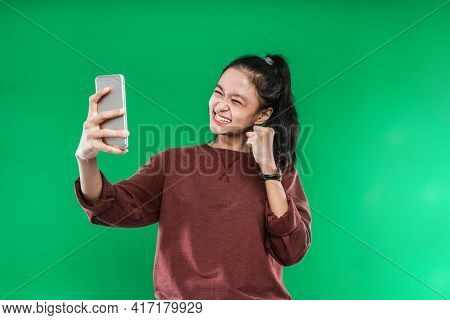 Portrait Beautiful Young Woman Looking At Something On The Cellphone With A Happy Expression On Gree