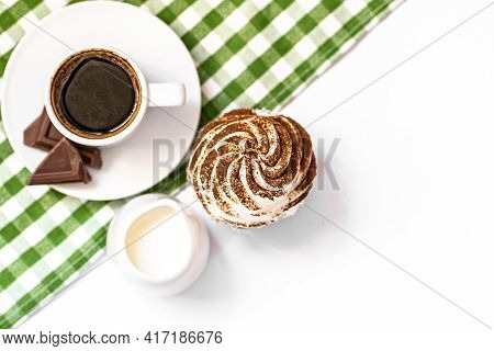 Dark Chocolate And Cocoa Chocolate Cupcakes With A Cup Of Hot Black Coffee On Green Napkin. Space Fo