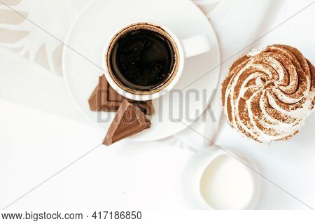 Dark Chocolate And Cocoa Chocolate Cupcakes With A Cup Of Hot Black Coffee On Green Napkin. Space Fo