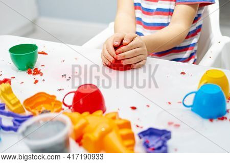 A Childs Hands Play With Bright Kinetic Sand On A White Table. An Educational Game Of Kinetic Sand W