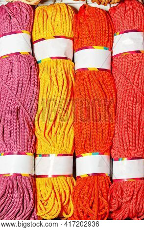 Rolls Of Bright Pink, Red, Yellow And Crimson Polyester Cord, Rolled. Vertical Image, Close-up, Copy