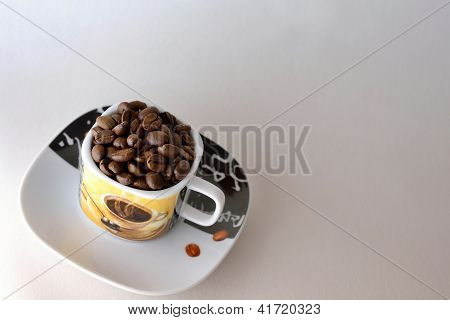เมล็ดกาแฟในถ้วยและจานรอง