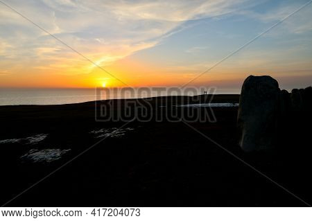 Colorful Partially Cloudy Sky At Sunset Over The Sea. Silhouettes Of Ales Stenar Megalithic Monument