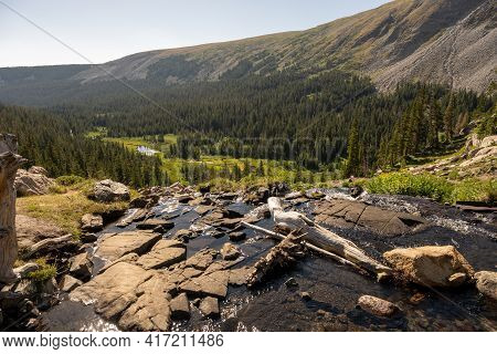 Water Flows Over Rocks Into Valley From Lake Isabelle In Colorado Mountains