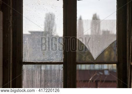 Selective Blur On The Shattered Glass Of A Broken Window With A Wooden Frame In An Abandoned And Van