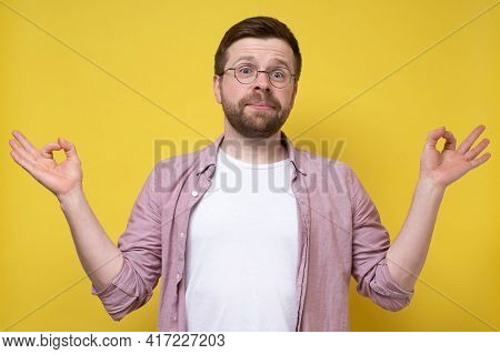 Funny Bearded Man With Glasses Meditates, Trying To Find Harmony And Balance, He Connects Thumb And 