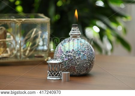 Burning Catalytic Purifying Lamp On Wooden Table. Interior Element