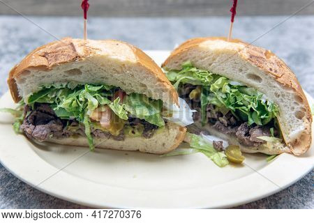Mexican Torta Sandwich Loaded With Meat And Vegetables Inside A Freshly Baked Bun For A Hearty Meal.