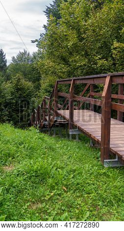 Very Clean And Modern Outdoor Wooden Stair On Downhill In Forest Vertical