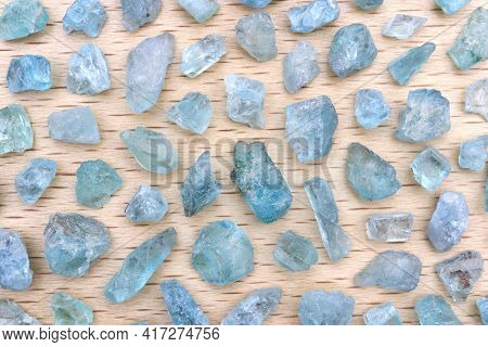 Apatite Rare Jewel Stones Filled Texture On Light Varnished Wood Background.
