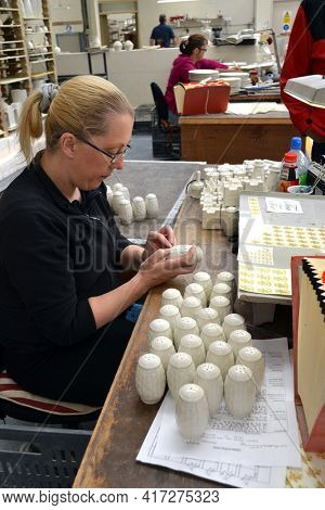 BELLEEK, NORTHERN IRELAND - MAY 19, 2011: Workers at a Belleek pottery factory putting decal on Salt and Pepper shakers, Ireland