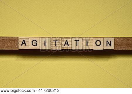Word Agitation Made From Wooden Letters Lies On A Yellow Table