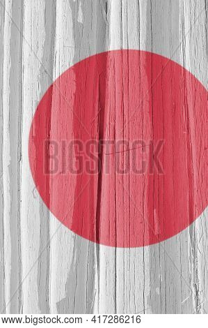 Fragment Of Japan Flag On A Dry Wooden Surface, Cracked With Age. Light Pale Faded Paint. Vertical B